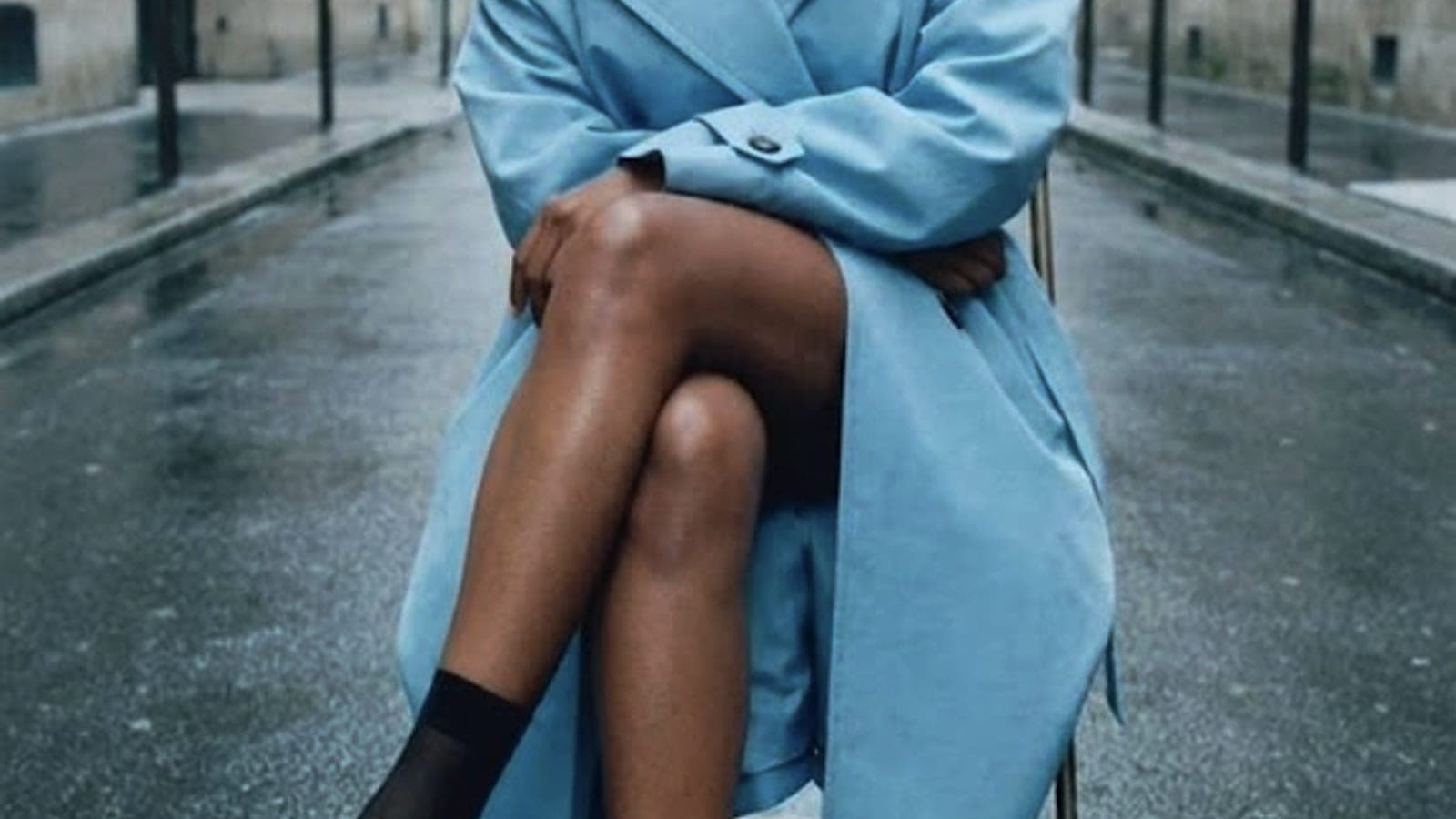 A blue coat on a rain-dark street, used as an editorial image for scent and memory.